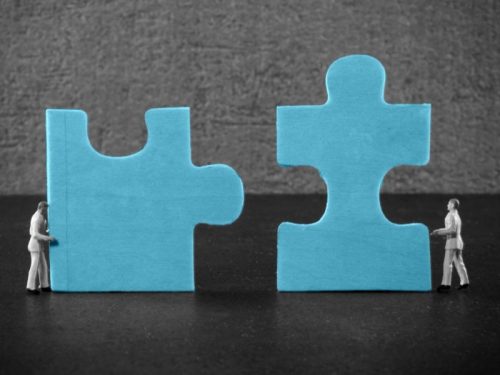 People moving puzzle pieces - business preparation